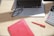 A close-up of a Canadian work visa on a wooden desk next to a laptop and notes.