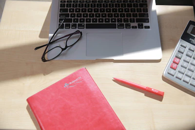 A close-up of a team member reviewing a manuscript with notes and a laptop on the desk.
