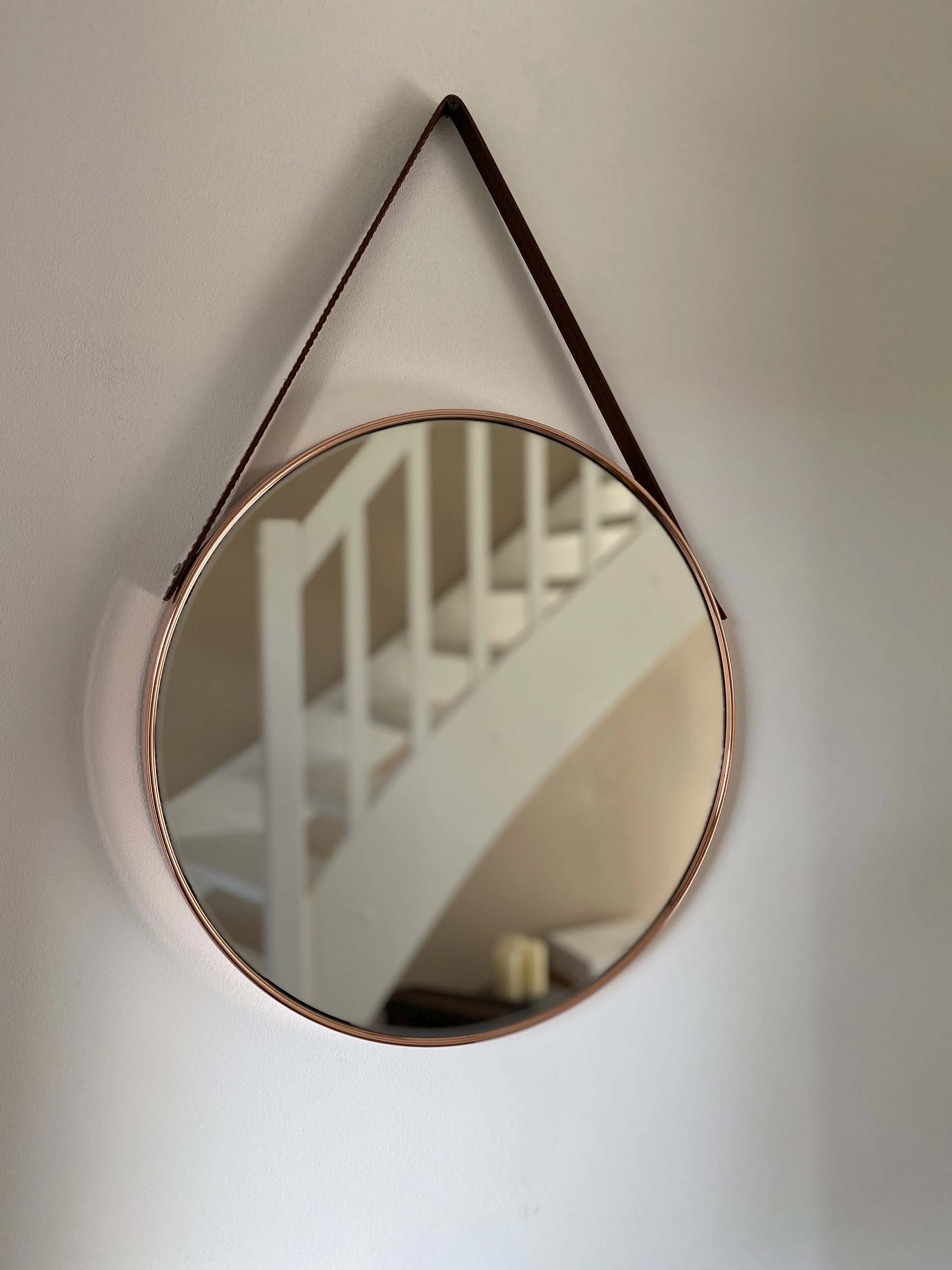 Wooden framed mirror on a white wall