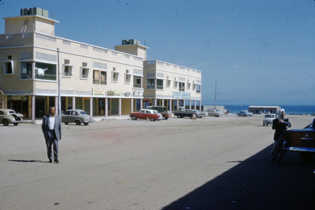 cars parked in front of white building during daytime