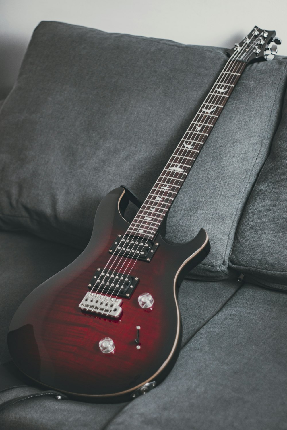 Guitarra eléctrica roja y blanca sobre textil negro
