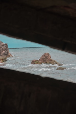 A sleek modern frame showcasing a still from a video of waves gently crashing on a rocky shore.