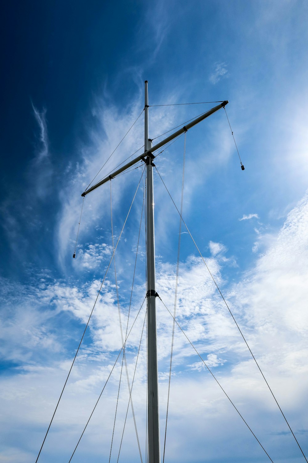 white wind turbine under blue sky and white clouds during daytime