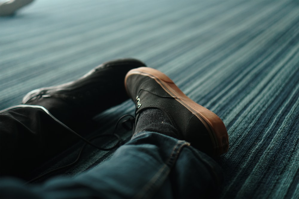 person in blue denim jeans and brown leather shoes