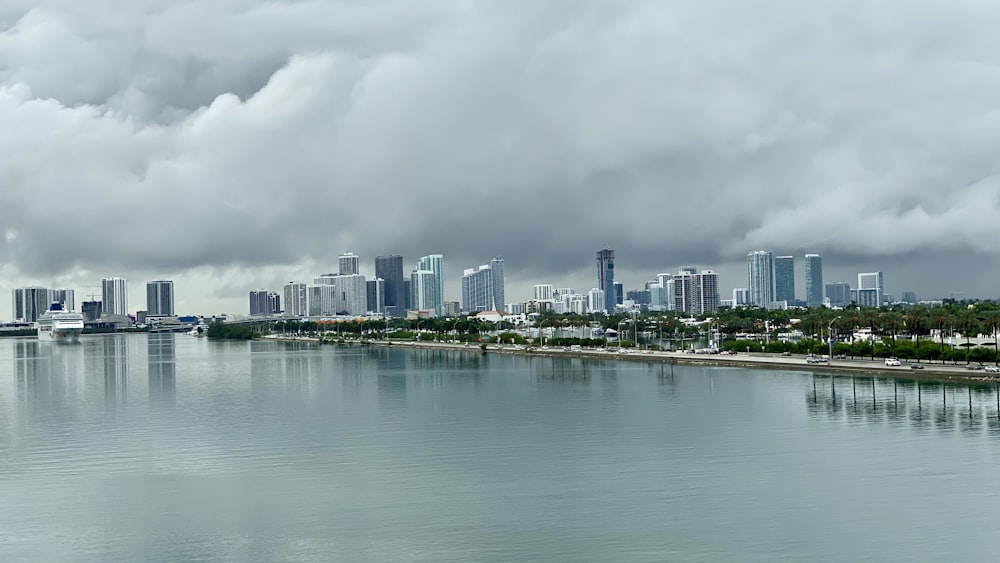 city skyline across body of water under cloudy sky during daytime