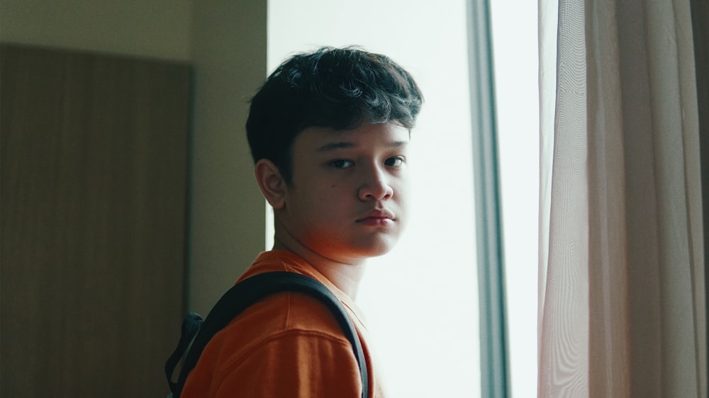 boy in orange and black shirt