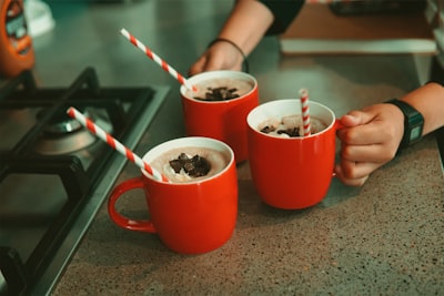 person holding red ceramic mug with white powder brunei teams background