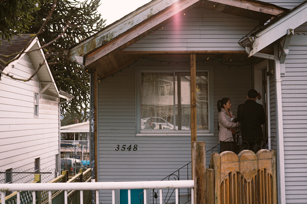 woman in blue denim jacket standing beside brown wooden fence