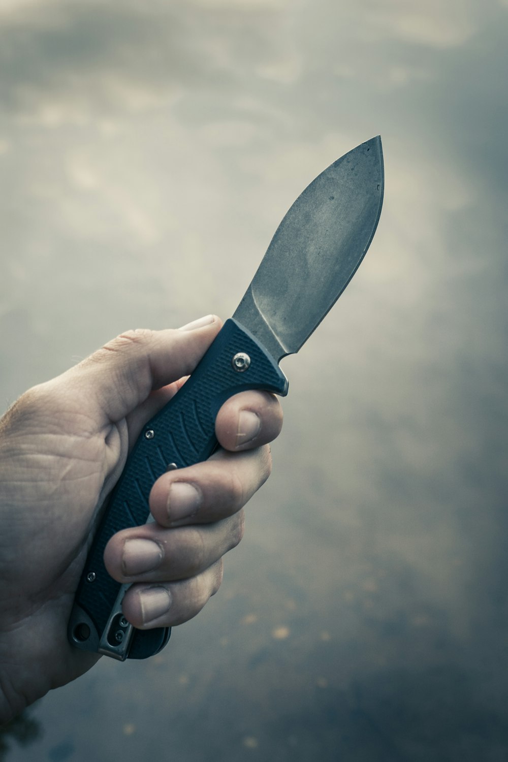 person holding black handle knife