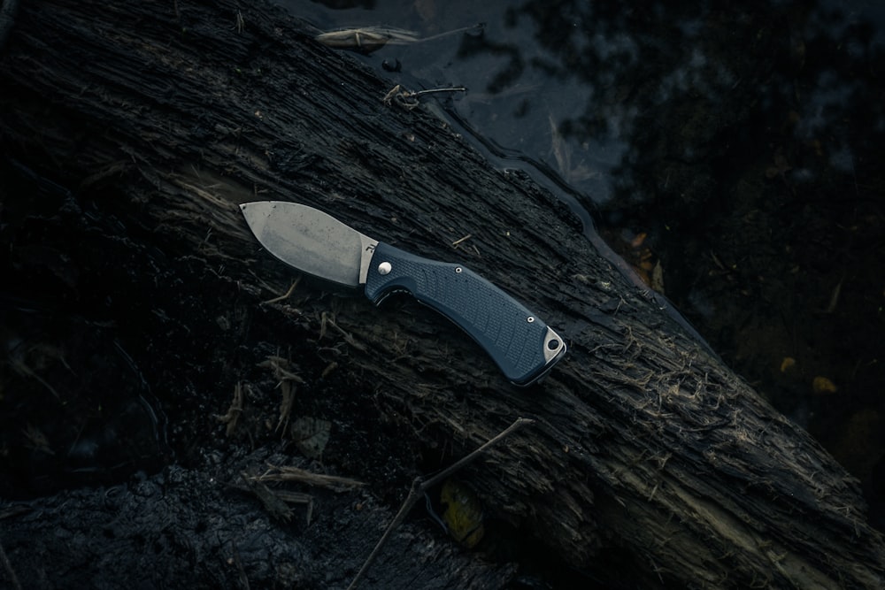 schwarz-silbernes Messer auf braunem Holz