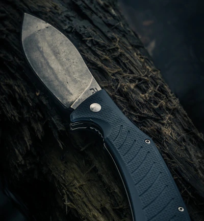 black and silver knife on brown wooden surface
