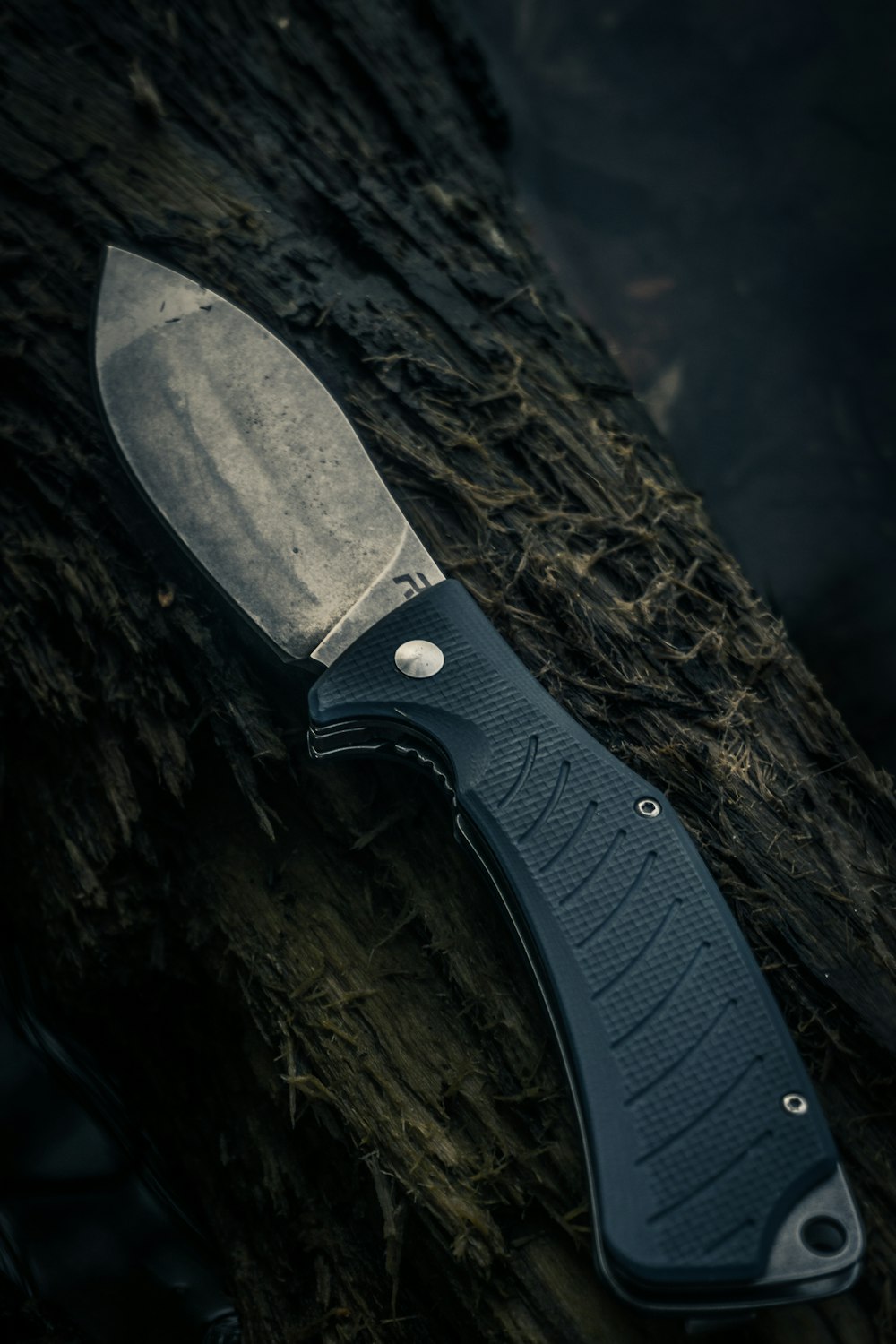 schwarz-silbernes Messer auf brauner Holzoberfläche