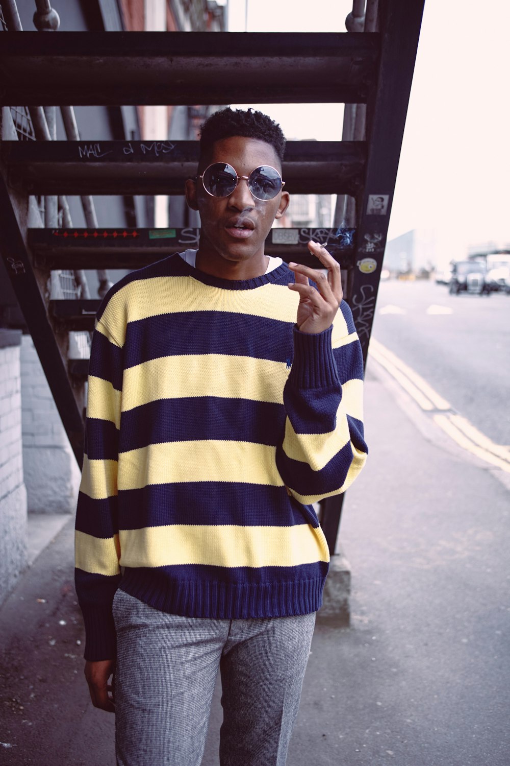 man in yellow and blue striped long sleeve shirt wearing black sunglasses