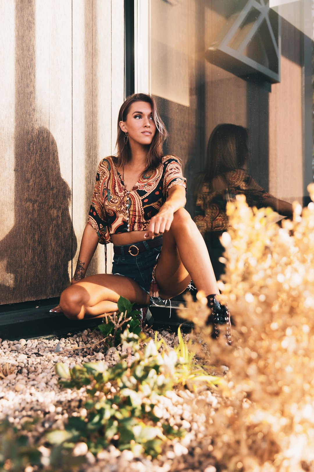 woman in black and white dress sitting on ground with yellow flowers