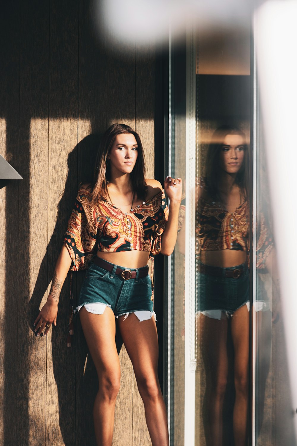 woman in black lace crop top and blue denim shorts