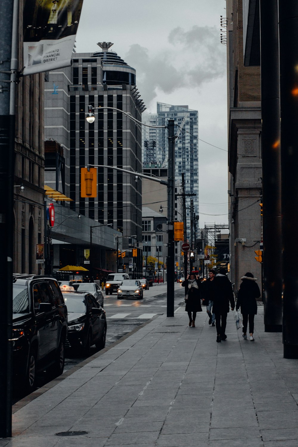 people walking on sidewalk near high rise buildings during daytime