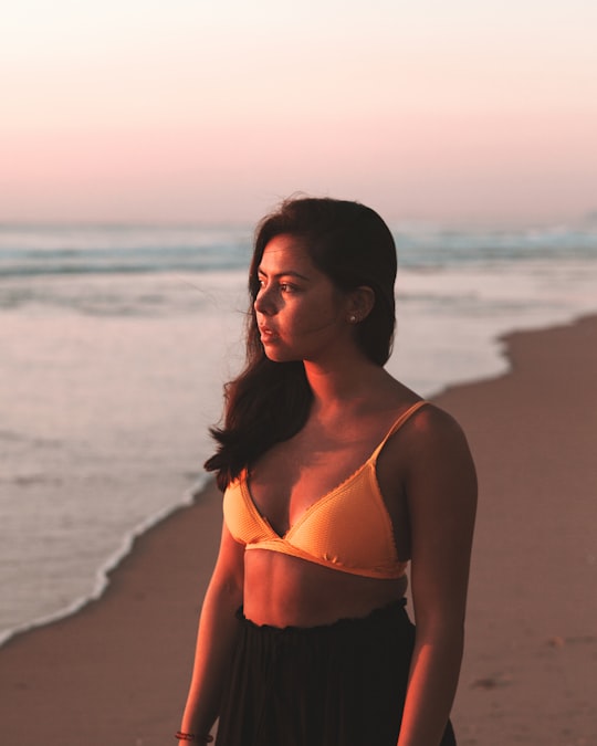 woman in white bikini top standing on beach during sunset in Surfers Paradise Australia