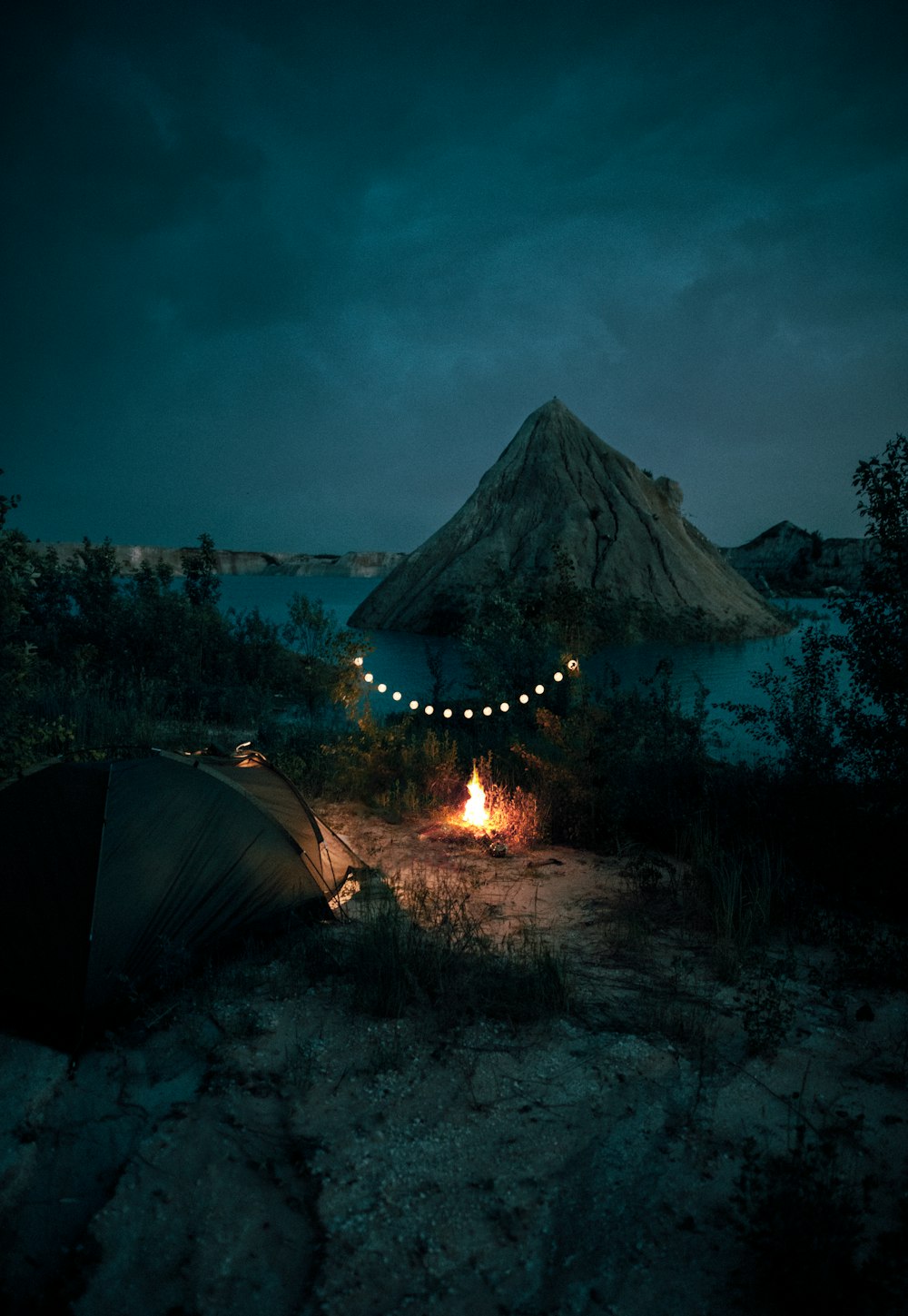 Feu de joie près de la tente et de la montagne pendant la nuit