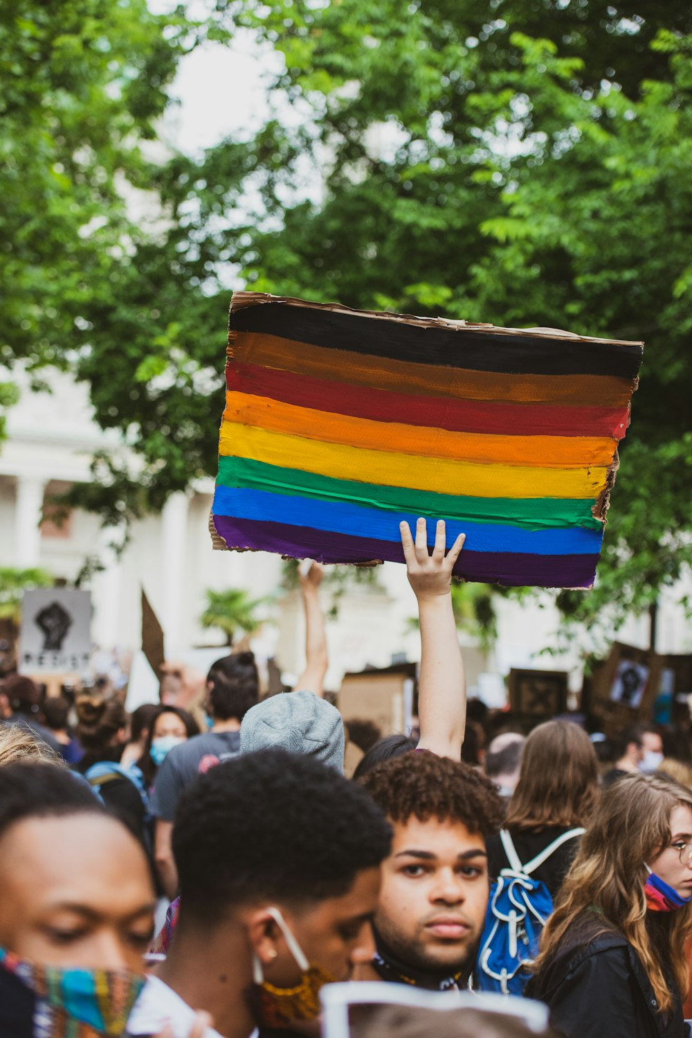 people holding multi colored flag during daytime