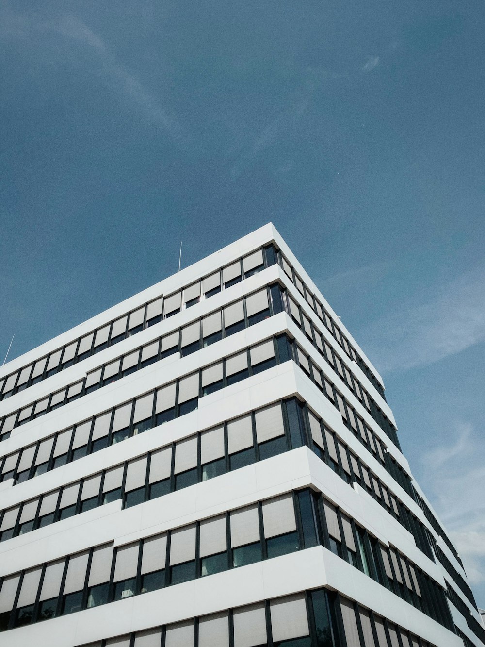 Bâtiment en béton blanc sous le ciel bleu pendant la journée