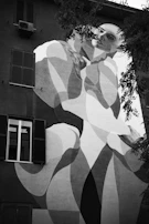 A large-scale mural on a building facade, depicting a flowing natural scene with stylized figures.