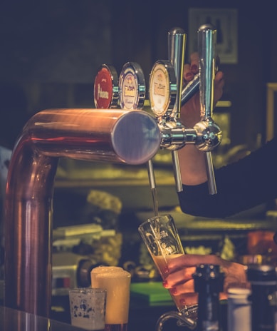 Close-up of a bartender expertly pouring a craft beer from a tap.