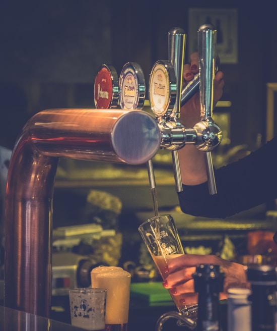 Close-up of a bartender expertly pouring a craft beer with foam on top