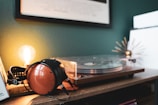 Close-up of headphones resting on a vinyl record player with soft lighting