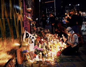 A peaceful candlelight vigil in front of a Saint Jude shrine at dusk.