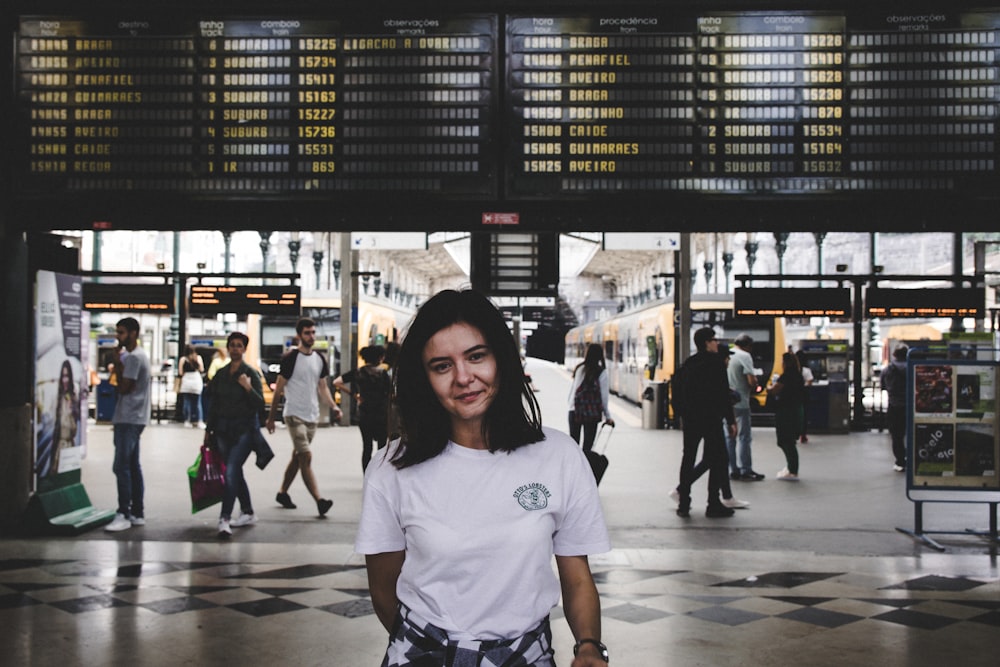 mulher na camiseta branca do pescoço da tripulação em pé na rua