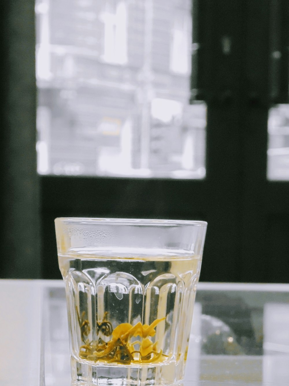 clear shot glass with yellow liquid