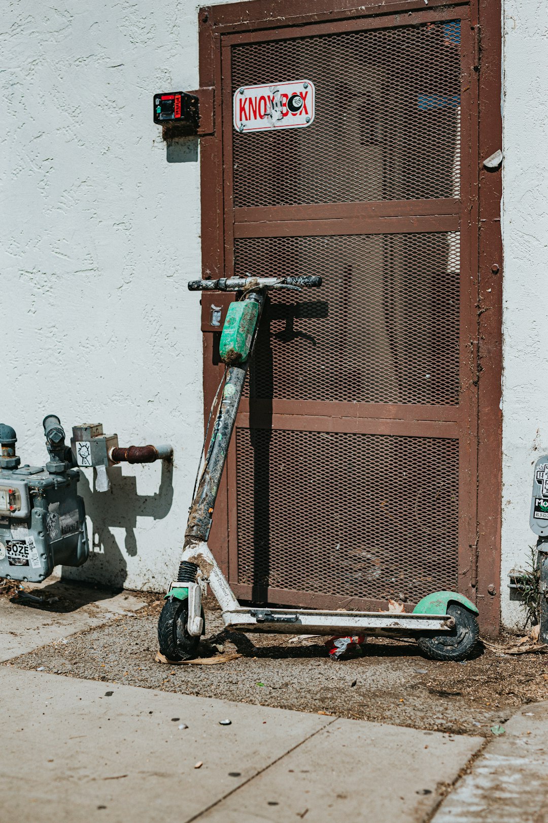 black and gray kick scooter beside brown wooden window