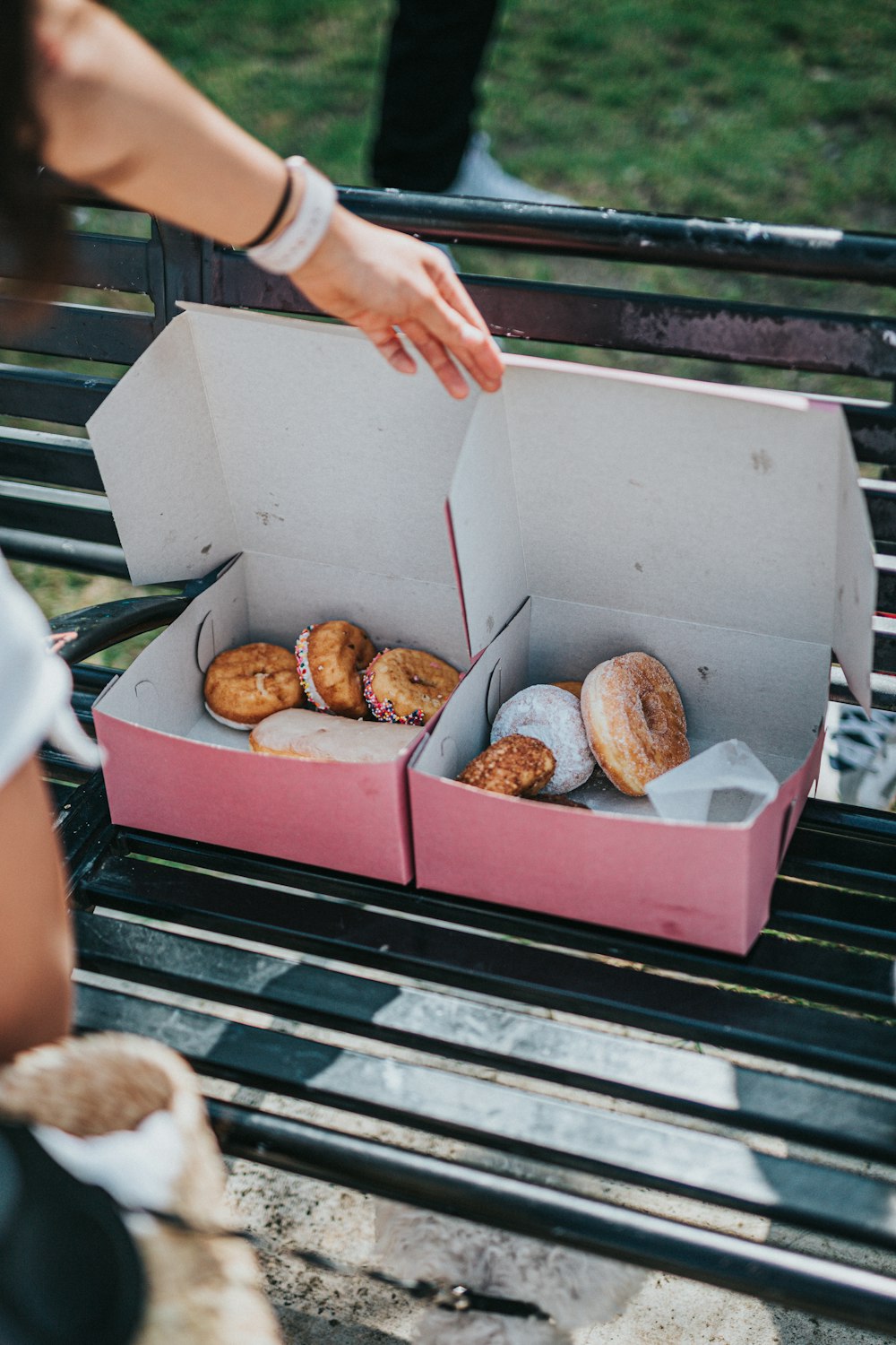 person holding white cardboard box with brown cookies