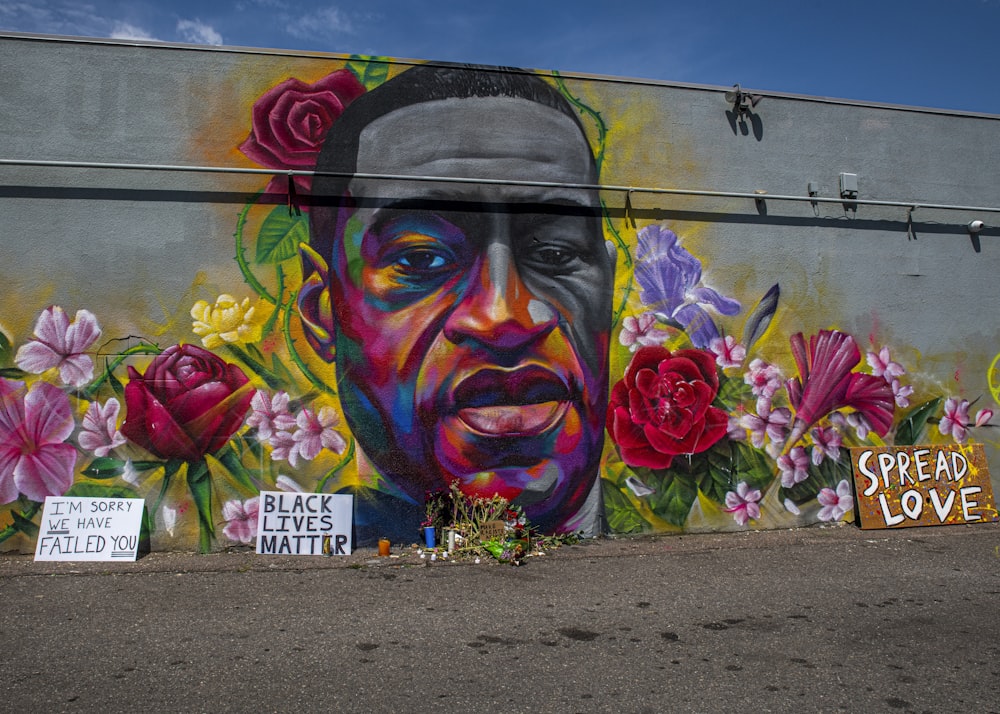 lila Blume neben Graffiti-Wand