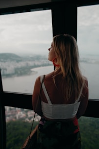 woman in white and black spaghetti strap top looking at the sea during daytime