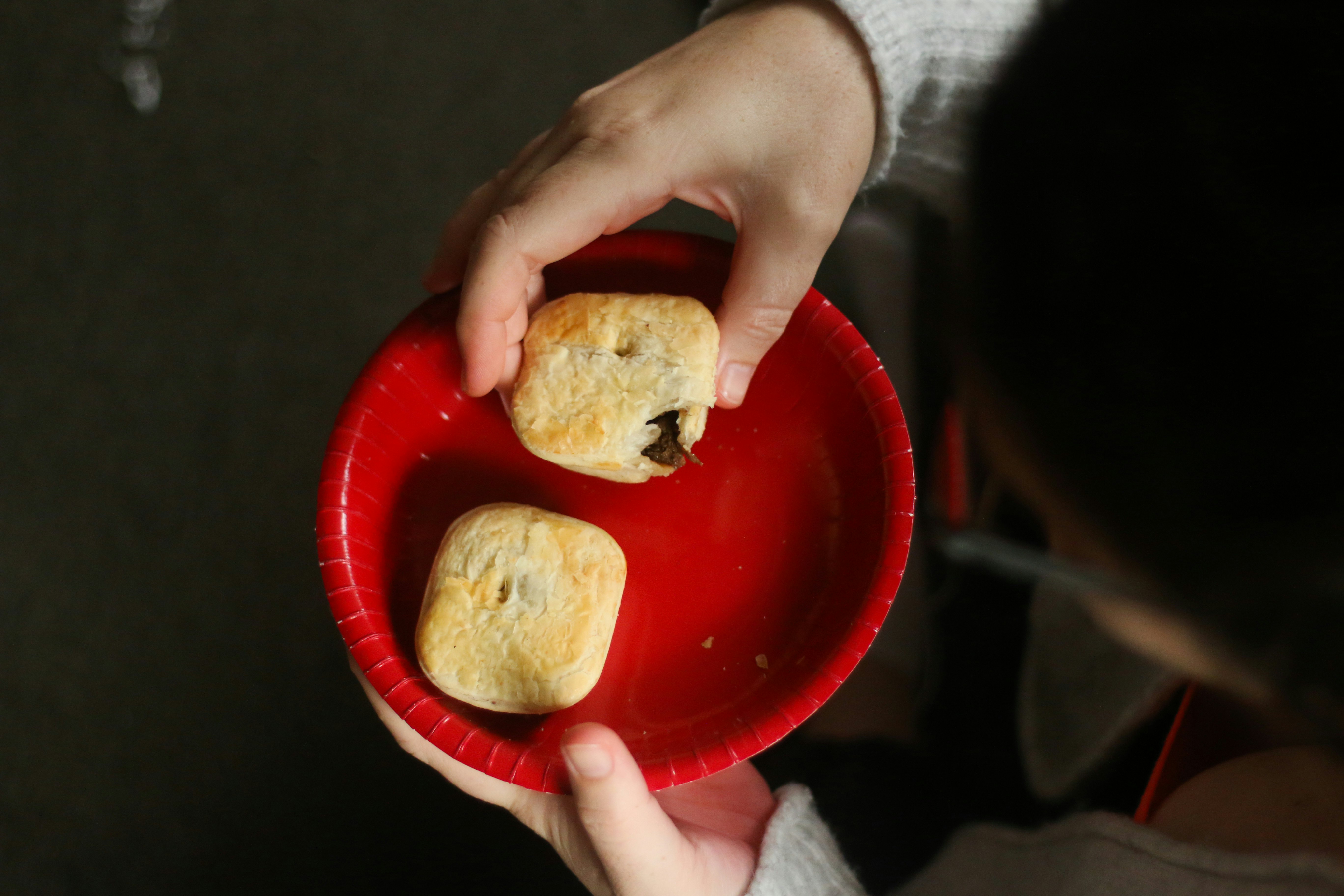 person holding bread on red plate