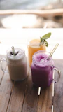 Glass jars filled with pitahaya jam and smoothies on a wooden table