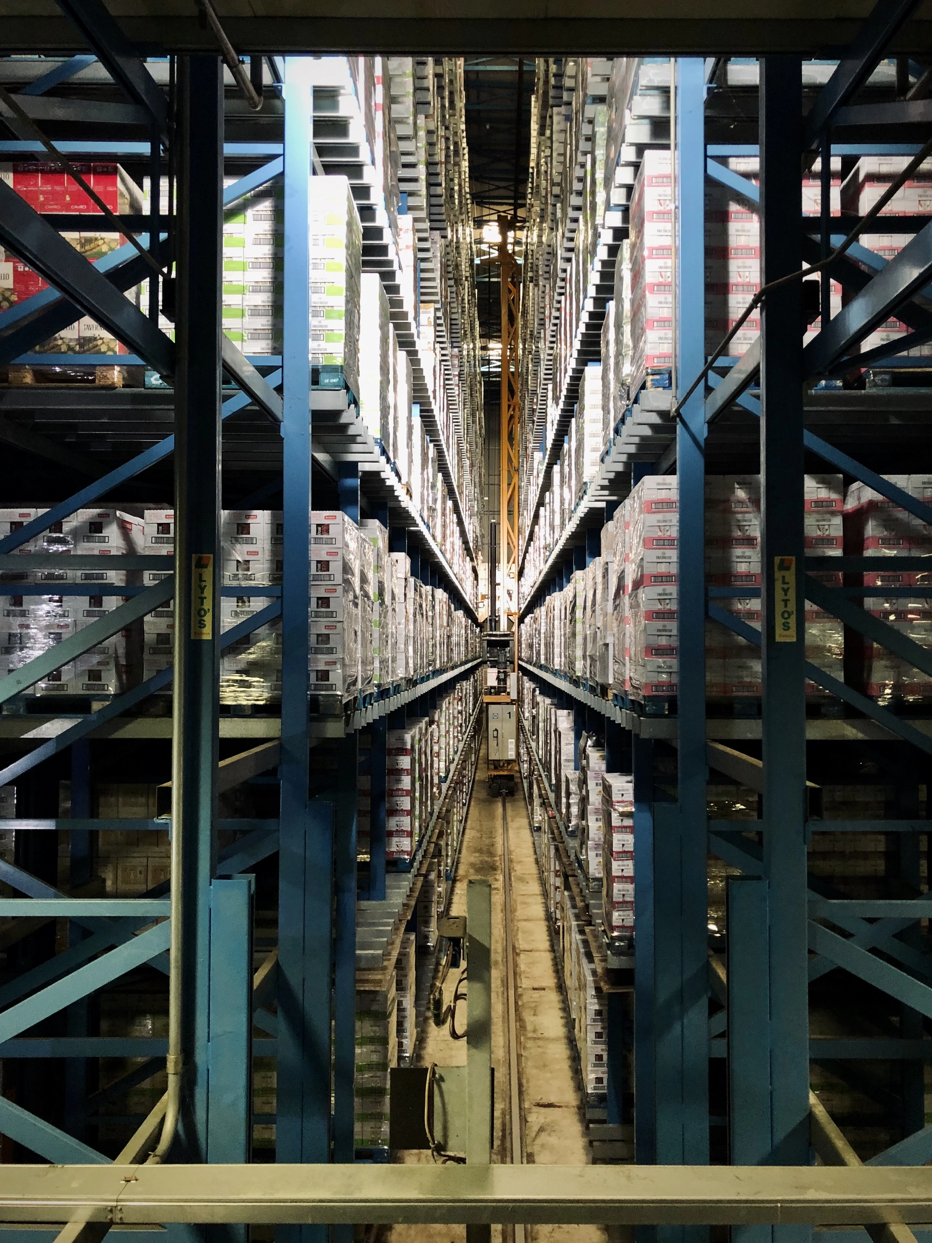 Allée d’un centre de distribution aux étagères remplies de cartons