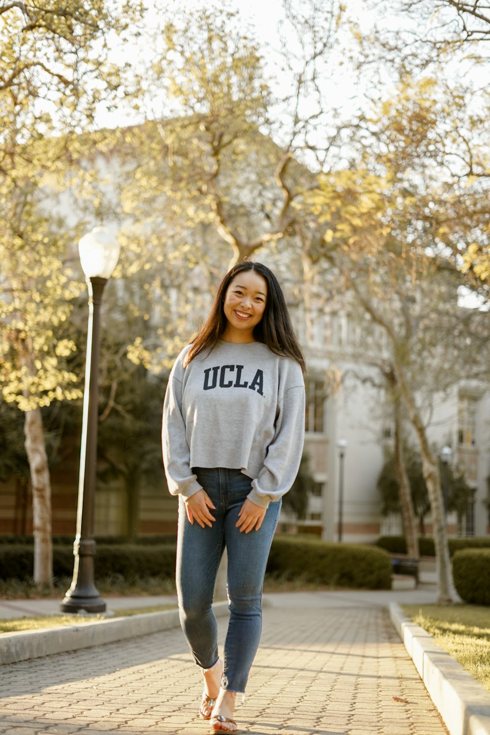 woman in gray sweater standing near lamp post