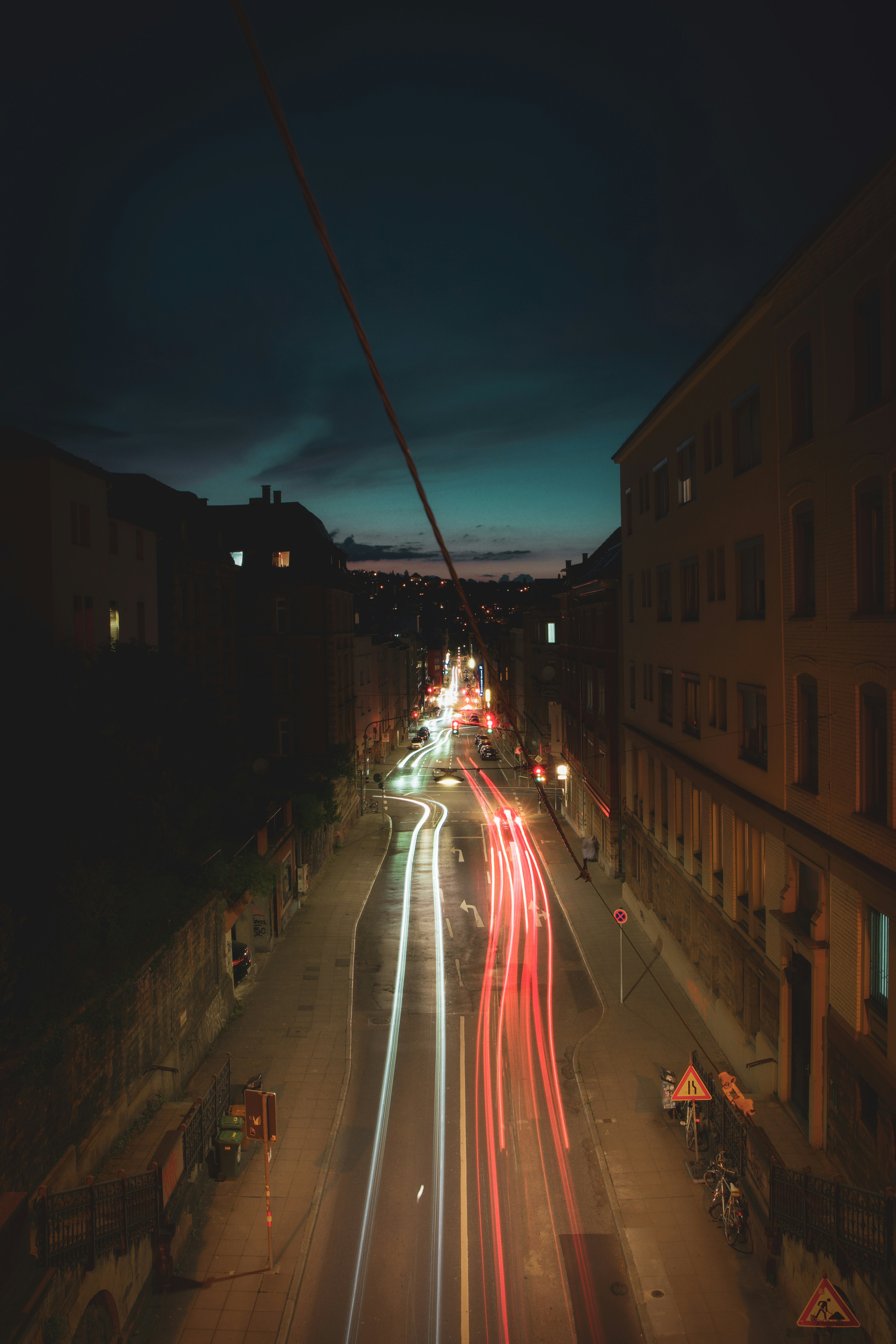 cars on road between buildings during night time