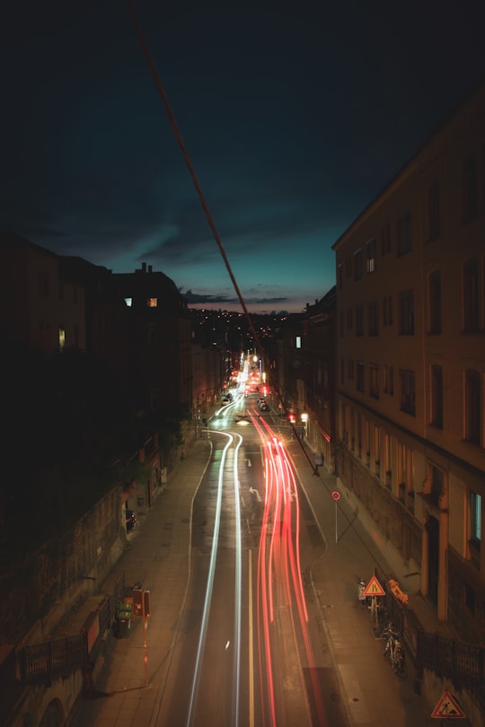 cars on road between buildings during night time in Stuttgart Germany