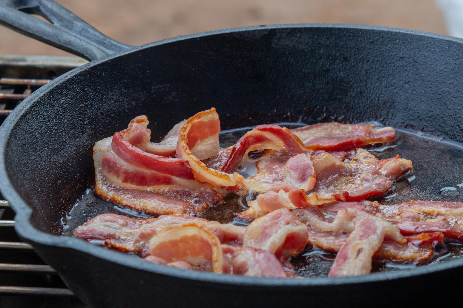 Bacon sizzling in a black skillet