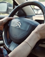 person holding black honda steering wheel