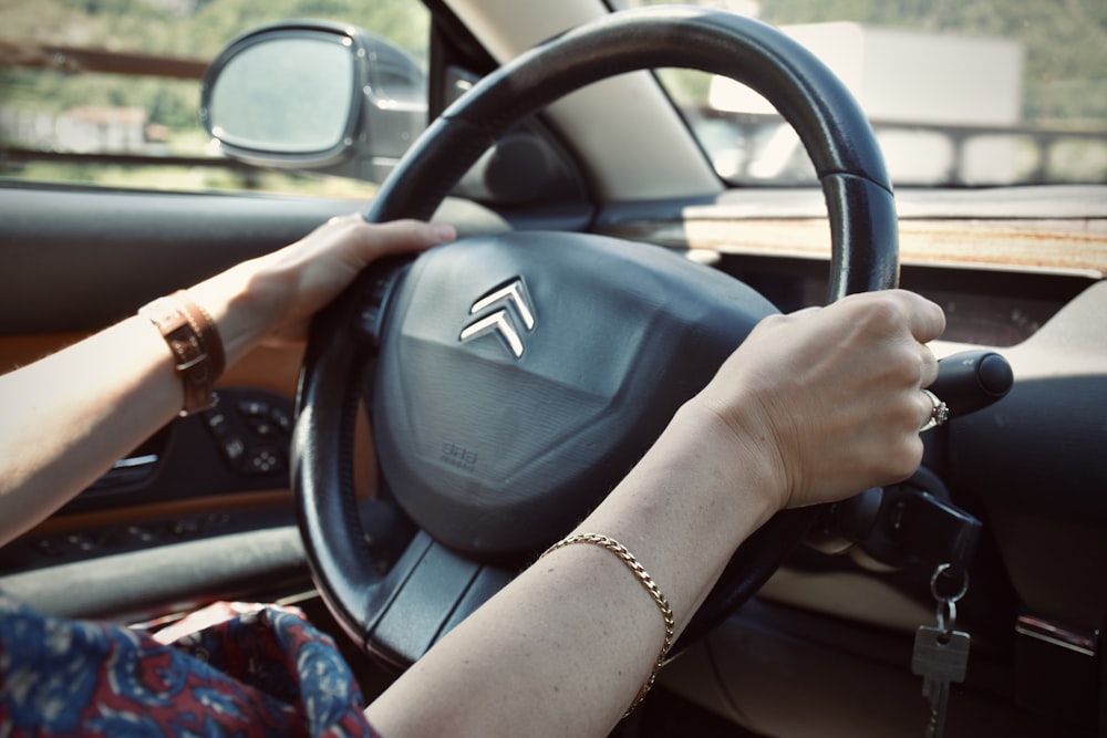 person holding black honda steering wheel