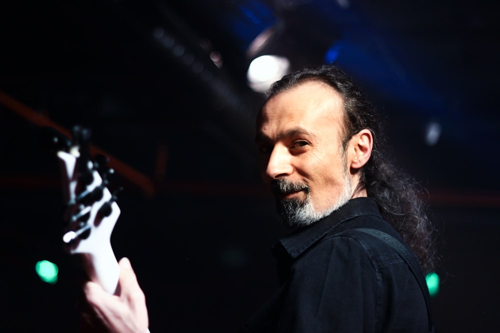 man in black shirt holding his head