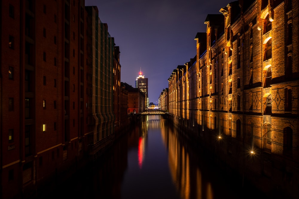 brown concrete building near body of water during night time