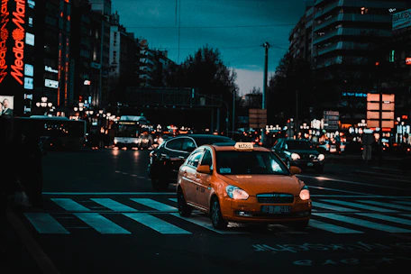 yellow taxi cab on pedestrian lane during night time