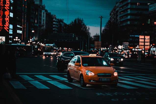 yellow taxi cab on pedestrian lane during night time