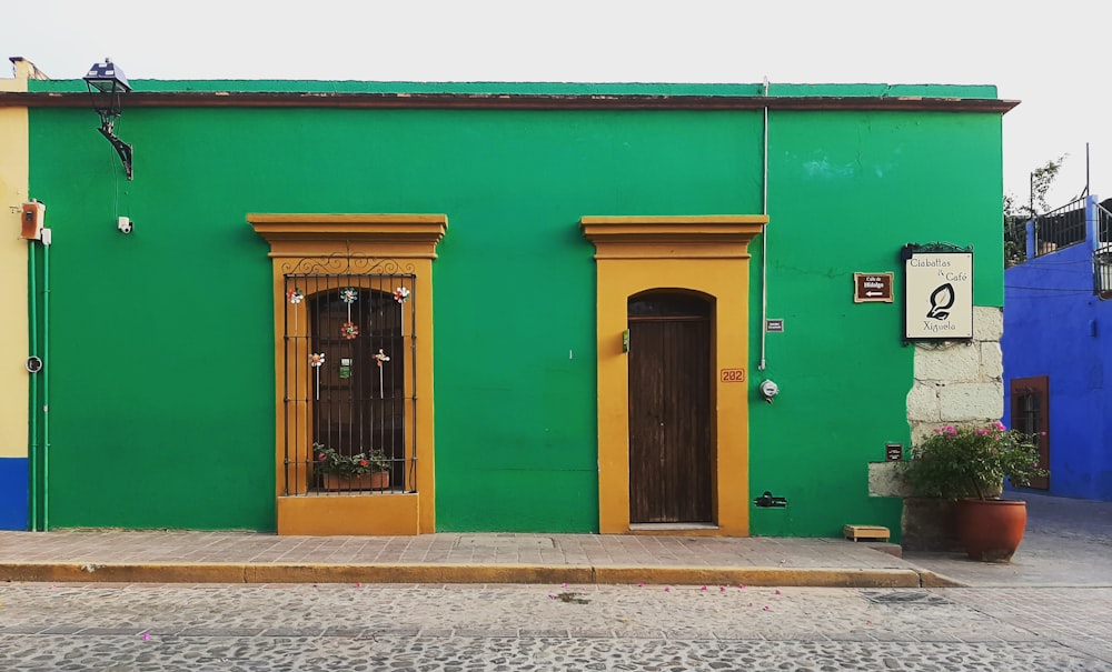 茶色のスチール製ドアレバー付き緑色の木製ドア