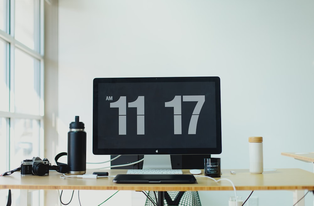 black flat screen computer monitor on brown wooden desk